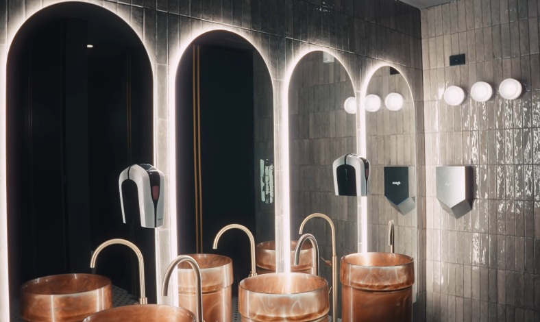 Commercial bathroom — copper sinks and arched mirrors
